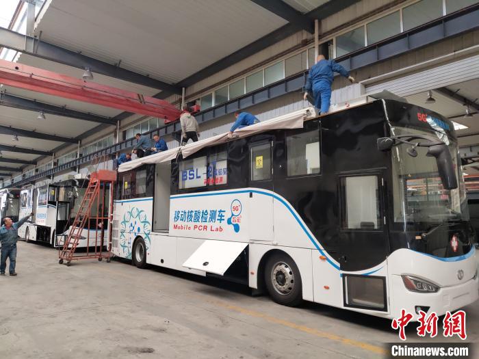 工人在组装5G智能移动核酸检测车车顶设备。 王鹏 摄 工人在组装5G智能移动核酸检测车车顶设备。 王鹏 摄